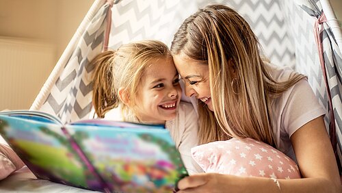 Mutter und Tochter lesen zusammen in einem Kinderbuch
