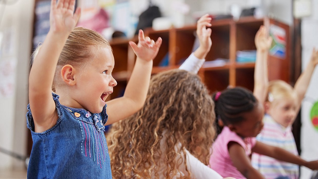 Kinder heben Arme in die Luft