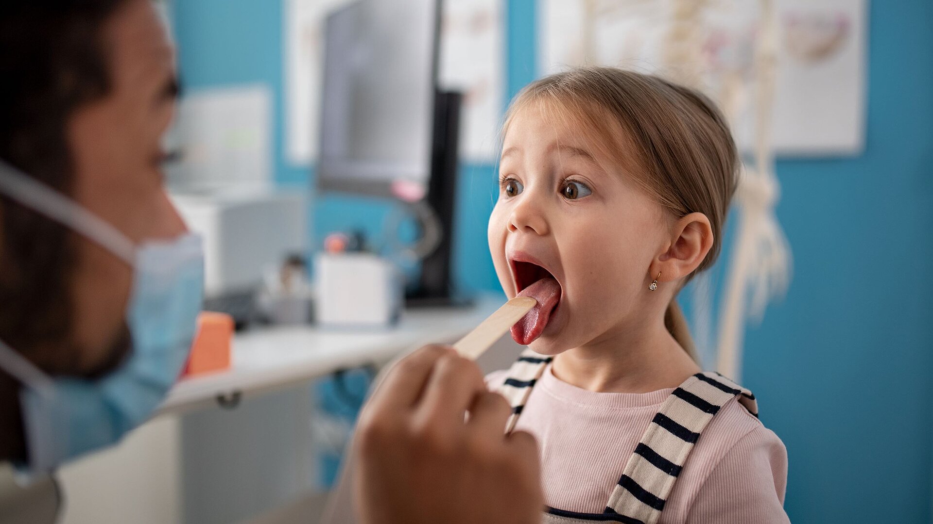ärztin kontrolliert den mund eines Kindes