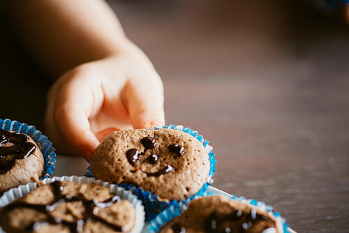 Kinderhand_greift_nach_einem_Muffin