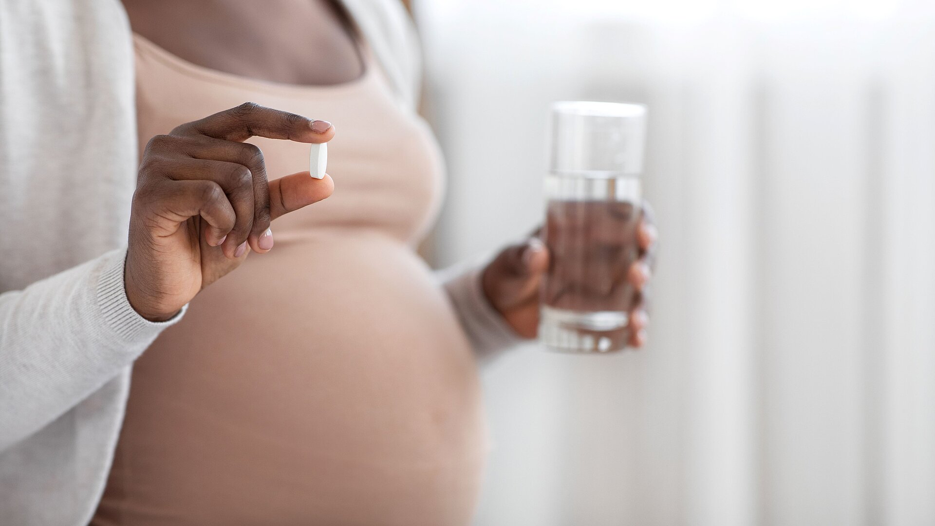 Schwangere Frau nimmt ein Medikament ein