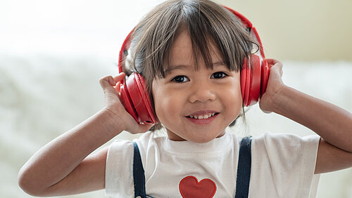 Glückliches Kind genießt es , Musik mit Kopfhörern zu hören