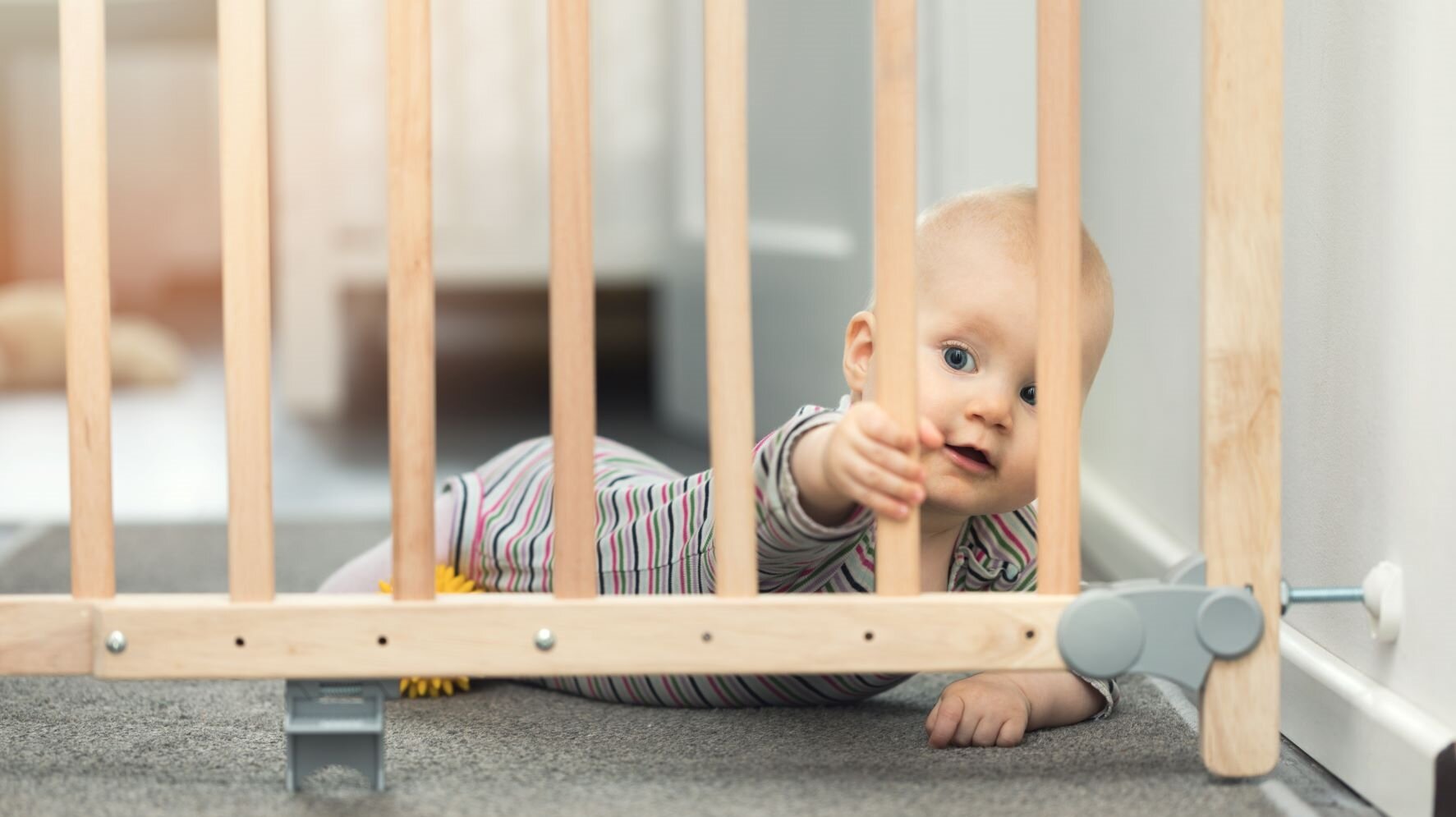 Baby krabbelt auf Treppengitter zu